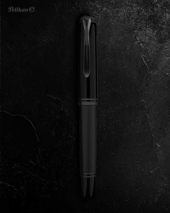 Pelikan Souverän M809 black matte fountain pen with gold accents and a silver clip, showcasing its elegant design.