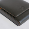 Close-up of a dark brown leather wallet on a light gray background