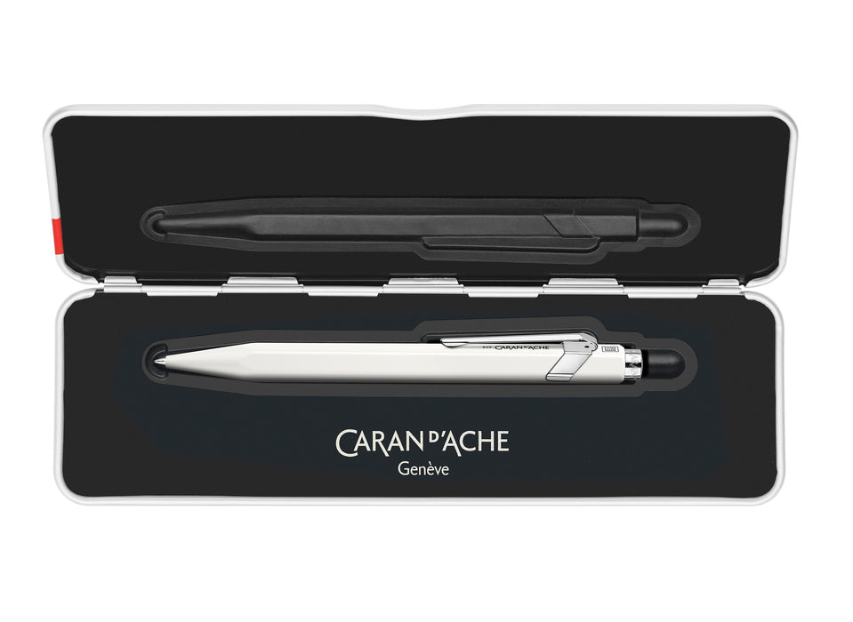 Caran D'Ache 849 rollerball pen with slim white barrel and silver clip, showcasing its sleek, compact design.