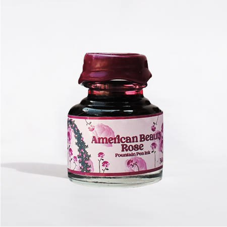 Papier Plume American Beauty Rose fountain pen ink bottle with red and pink ink, showcasing elegant packaging and vibrant color.