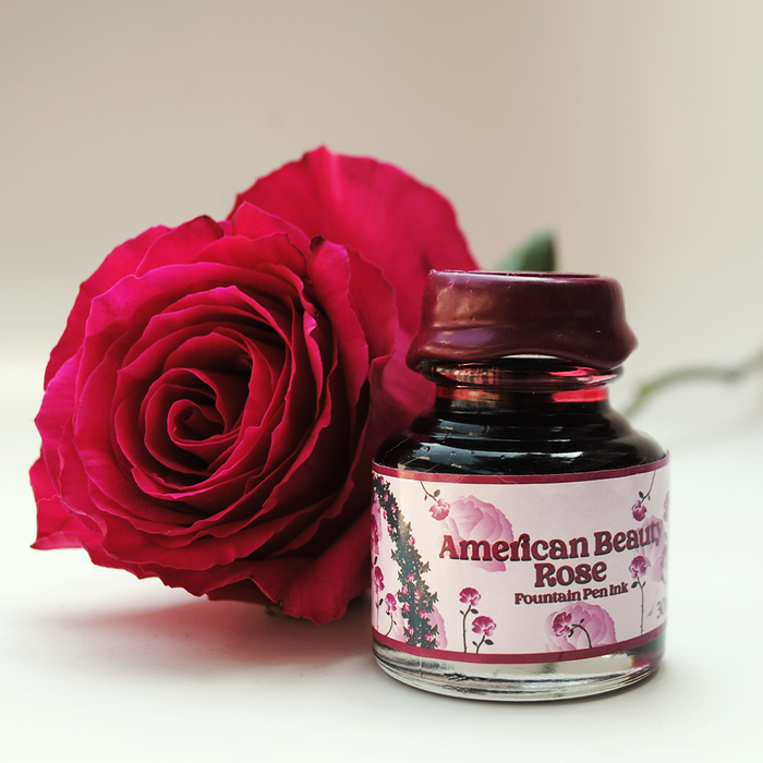 Papier Plume American Beauty Rose fountain pen ink bottle with vibrant red and pink ink inside.