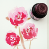 Papier Plume American Beauty Rose fountain pen ink bottle with vibrant pinkish-red ink in a glass container.