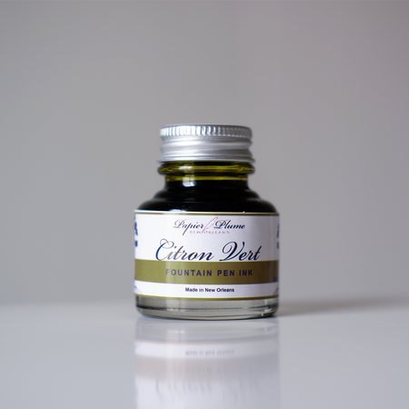 Papier Plume fountain pen ink in vibrant citron vert green, showcasing the bright, smooth ink in a glass bottle.