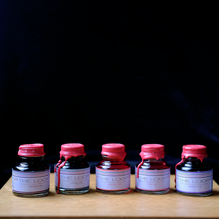 Papier Plume Loop Series fountain pen ink bottle with vibrant ink inside, designed for smooth ink flow and elegant writing.