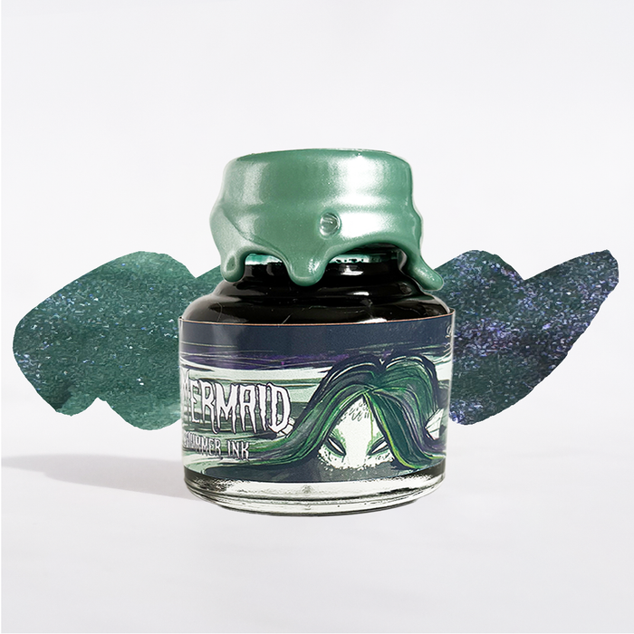 Papier Plume Swamp Mermaid shimmer fountain pen ink in a glass bottle with vibrant green and teal hues and intricate label design.
