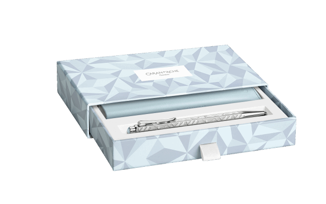 Caran D'Ache Ecridor Alpine Frost and Polar Blue ballpoint pen set with leather case, featuring sleek metallic pens on a detailed background.